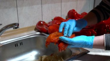 Kavrulmuş biberlerin kabuklarını soyar ve tohumlarını soyarlar.