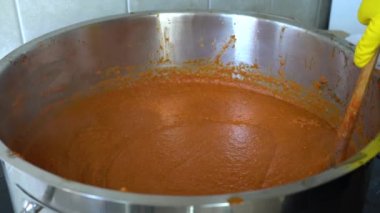 Ev yapımı Ajvar 'ı demlikte pişirip karıştırmak 