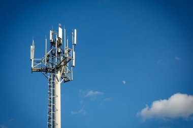 Telekomünikasyon kulesi 4G, 5G vericili. Telekomünikasyon kulesinde mavi gökyüzüne karşı verici antenleri olan bir baz istasyonu.