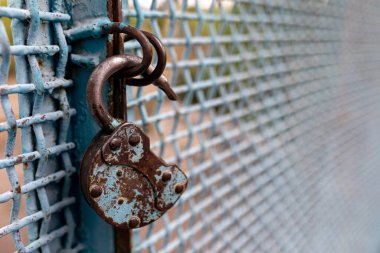 Anahtarı olmayan paslı açık bir kilit metal bir çite asılı. Güvenlik kavramı. Seçici odaklanma. Boşluğu kopyala