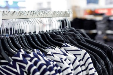 Mağazada örgü süveter ve gömlekli askılar var. Alışveriş merkezinde gündelik kıyafet satışı. Modern moda mağazası. - Evet. Bulanık