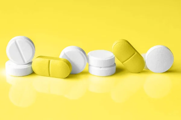Creative photo of tablets on a trendy Illuminating Yellow background. Concept of inventing a cure for coronavirus in 2021 — Stock Photo, Image