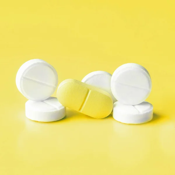 Pills on Illuminating Yellow background. Concept of inventing a cure for coronavirus in 2021 — Stock Photo, Image