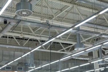 Modern bir deponun ya da alışveriş merkezinin tavanında diyot ışıklandırmalı ve havalandırmalı lambalar. İçeriden bak. Seçici Odaklanma