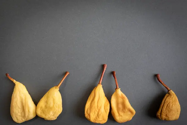 Αποξηραμένα Αχλάδια Σκούρο Γκρι Φόντο Μια Ομοιόμορφη Σειρά Αποξηραμένων Φρούτων — Φωτογραφία Αρχείου