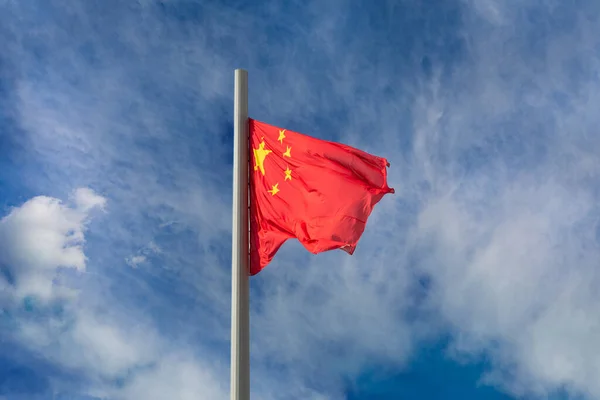 The national flag of China People\'s Republic of China waving against a cloudy sky.