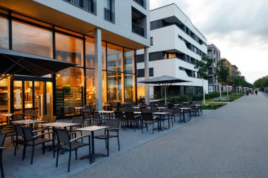 Akşamları boş kafesi olan bir yerleşim yerinin sokağı. Modern kentsel alan, teknik yenilik ve manzara altyapısını birleştirir. Heilbronn, Almanya - 12 Ağustos 2019