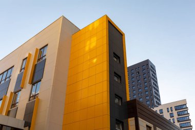 Sarı-kahverengi, modern havalandırmalı cephe. Yüksek binaların ya da büyük yerleşim alanlarının modern cepheleri.