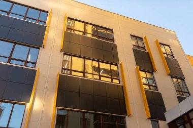 Pencereli bej ve kahverengi modern havalandırmalı cephe. Yeni elit bir konut binasının ya da alışveriş merkezinin parçası. Şehir gayrimenkullerinin bir parçası.