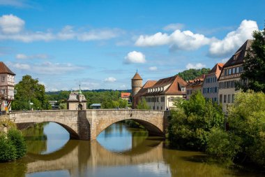Schwabisch Hall, Baden-Wurttemberg 'in tarihi merkezindeki Kocher nehri üzerindeki eski taş köprü. Schwabisch Salonu, Almanya - 13 Ağustos 2019.