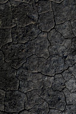 Çatlak siyah zeminin üst görüntüsü, doğal arka plan. Dikey.