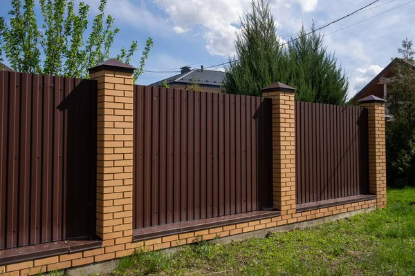 Ogrodzenie lub ogrodzenie z brązowego metalu i cegieł kolumn. Koncepcja bezpieczeństwa, — Zdjęcie stockowe