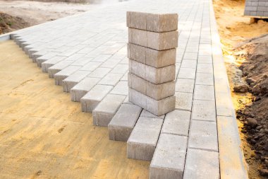 Gri asfalt levhalarla yüzeyin en üst görüntüsü. Kumlu karışım ile yüzey görünür. Döşeme levhaları dizilmeye hazır..