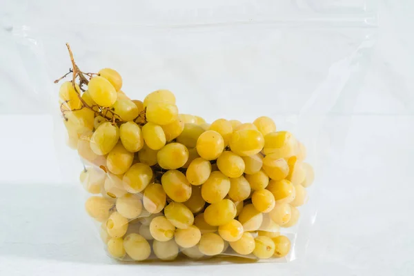 Uvas Amarillas Doradas Dulces Jugosas Cerca Bolsa Plástico Sobre Fondo —  Fotos de Stock