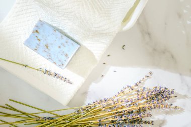 Beyaz pamuk havlular, lavanta sabunu, ve mermer zemin üzerinde lavanta çiçekleri, ürün sergisi için fotokopi alanı olan düz bir yer. Aromaterapi, rahatla, spa konsepti
