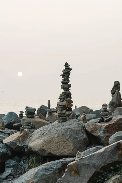 Stone pyramids on the beach at sunset. Balance, tranquility, harmony concept