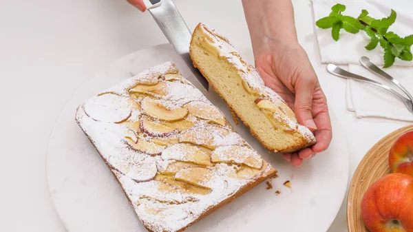 Apple pie. Fresh baked apple biscuit close up on white background. Woman cuts cake