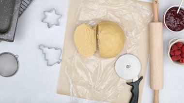 Kurabiye hamuru mutfak masasına yakın. Ahududu reçelli kurabiyeler pişirme işlemini kapatın.