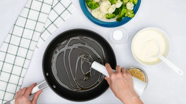 Chef pouring olive oil into frying pan. Vgetable casserole step by step recipe, cooking process, flat lay