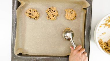 Çikolatalı kurabiye tarifi. Kurabiye hamurunu tepsiye koyan kadın, yakın çekim, yukarıdan görüş