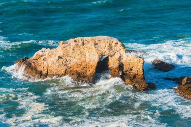 Kayalık kayalıklar ve fırtınalı turkuaz renkli okyanus dalgaları