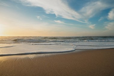Gün batımında boş kumsal ve bulutlu gökyüzü. Rahatlama, sakinlik, sükunet, tatil konsepti, kopyalama alanı