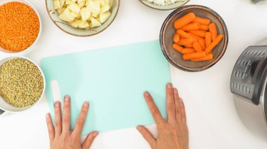 Mercimek çorbası malzemeleri. Kırmızı mercimek, yeşil mercimek, soğan, havuç, patates ve beyaz arka planda biraz baharat..