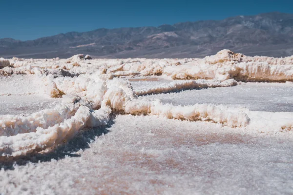 Salt flats, upheaved salt plates below sea level in Death Valley National Park. Close up texture. Badwater Basin, famous touristic destination