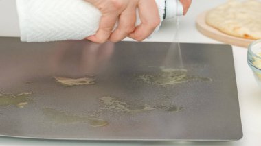 Fırın tavasında zeytinyağı spreyi kullanan kadın. Adım adım pizza pişirme işlemi, tarif
