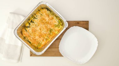 Ekmek kırıntıları ve parmesan peynirle kaplı kremalı Alfredo soslu kuşkonmaz güveci. Fırından yeni çıkmış taze yemek.