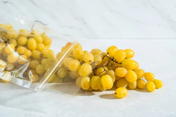 Aglomerado Uvas Perto Saco Plástico Fundo Mármore Claro — Fotografia de Stock