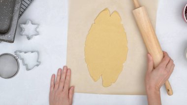 Ahududu reçeli tarifli noel kurabiyeleri. Aşçı kurabiye hamurunu mutfak masasına koyar, yukarıdan görür.