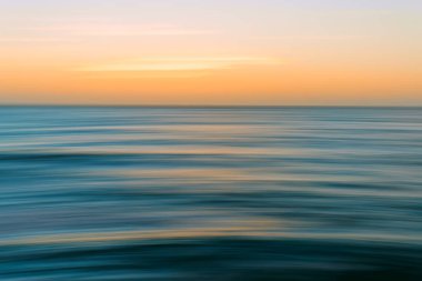 Gün batımı deniz manzarası parlak mavi, cyan, sarı renkler, hareket bulanıklığı, kopyalama alanı