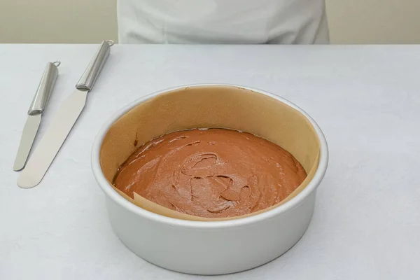 Cake pan with cake batter close up on kitchen table, close up baking process. Chocolate cake step by step recipe