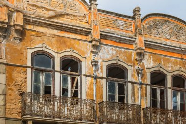 Portekiz 'de terk edilmiş bir binada çatlak duvarlar, demir balkonlar ve soluk mimari detaylar sergileniyor..