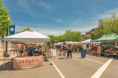 Washington D.C. USA, 25 Mayıs 2025. Seylou Fırını, popüler sokak pazarındaki beyaz çadırın altında taze ekmek ve mal sunuyor.