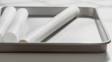 Beyaz parşömen kağıtları yemek hazırlamak için temiz metal bir yemek tepsisinin üzerinde duruyor..