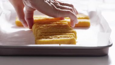 Eller dikkatlice parşömen kaplı bir tepside sıralanmış balık çubuklarını bile yerleştirir. Yüksek kalite 4k görüntü