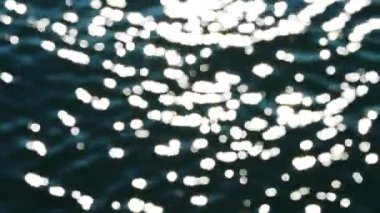 Güneş ışığı dalgalanan su yüzeyinde parıldıyor. Yüksek kalite 4k görüntü