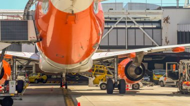 Lizbon, Portekiz, 20 Mayıs 2025. EasyJet uçakları görünür motor, iniş takımları ve yer destek araçlarıyla birlikte kapıda park halinde..