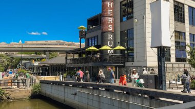 Washington D.C., ABD, 25 Mayıs 2025. İnsanlar restoranların ve Rom binasının yakınındaki nehir kıyısında yürüyüp rahatlıyorlar..