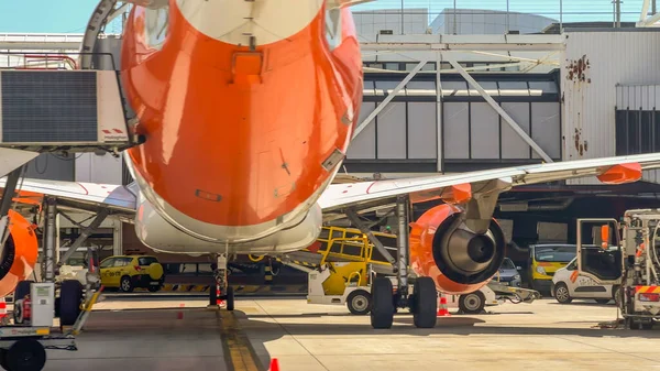 Lizbon, Portekiz, 20 Mayıs 2025. EasyJet uçakları görünür motor, iniş takımları ve yer destek araçlarıyla birlikte kapıda park halinde..