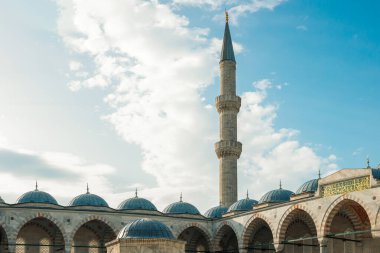 İstanbul 'daki Mavi Cami' de bir sıra kubbe ve kemerin üzerinden yükselen uzun bir minare bulutlar gökyüzünde sürükleniyor..