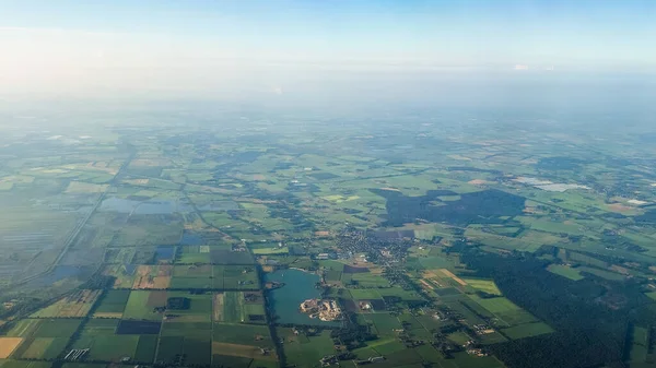 Yeşil tarlalar ve küçük kasabalardan oluşan bir mozaik tüm araziye yayılır..