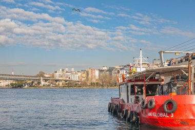 İstanbul, Türkiye, 7 Ocak 2025. Römorkör AK Küresel 3 rıhtım yakınında yüzüyor. Şehir silüeti ve arka planda köprü var..
