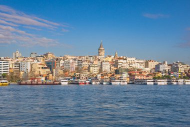 İstanbul, Türkiye, 7 Ocak 2025. Liman manzaralı Galata Kulesi kıyıya yanaşmış feribotlarla.