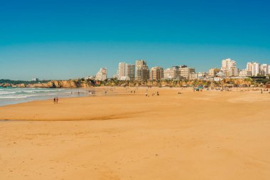 Portimao, Portekiz, 21 Şubat 2026. Praia da Rocha sahilinin geniş bir manzarası var. Algarve kıyı şeridi boyunca altın kum, kayalıklar ve modern binalar var..