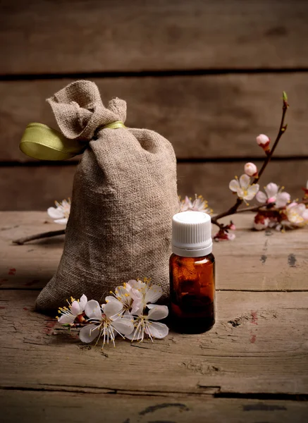 Botella de aceite de aroma esencial con bolsa de hierbas sobre un fondo de madera. Bodegón Vintage —  Fotos de Stock