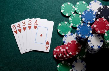 Casino fişi ve floş kartları kombinasyonu yeşil masada. Poker oyun kavramını