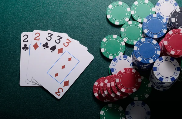 Casino chips and full house cards combination on the green table. Poker game concept